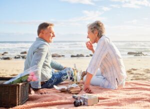 Older couple enjoying summertime picnic on the beach