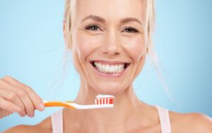 Happy mature woman holding her toothbrush