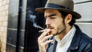 Man standing outdoors, smoking a cigarette